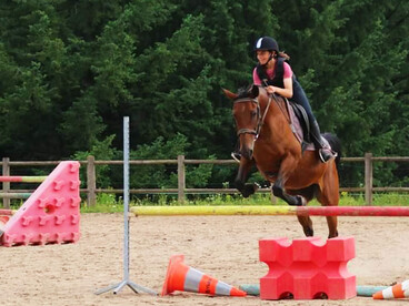 jeune fille pratiquant du saut d'obstacle à cheval