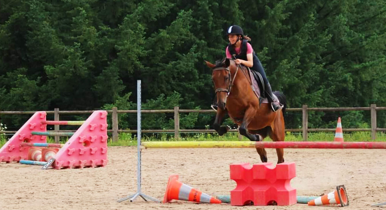 jeune fille pratiquant du saut d'obstacle à cheval