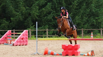 jeune fille pratiquant du saut d'obstacle à cheval