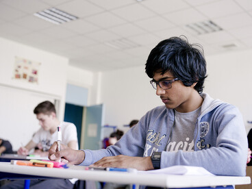 Jeune homme ecrivant sur son cahier